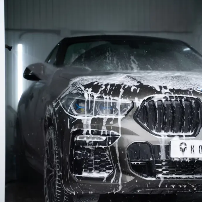 Detailer applying foam wash with pressure sprayer