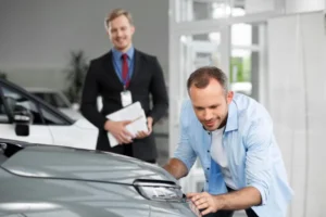 Professional detailing business owner managing a luxury vehicle detailing studio with trained technicians and modern equipment