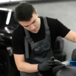 Professional detailer preparing a vehicle for ceramic coating through paint decontamination, correction and surface inspection